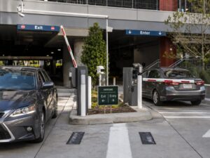 Commercial parking entry and exit lanes with ticket dispenser, payment terminal and barrier gates