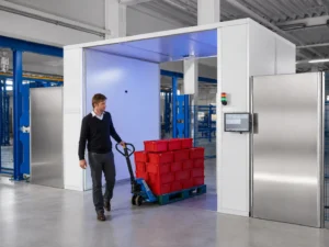 Worker moving tagged inventory through an RFID monitoring gate in an industrial warehouse
